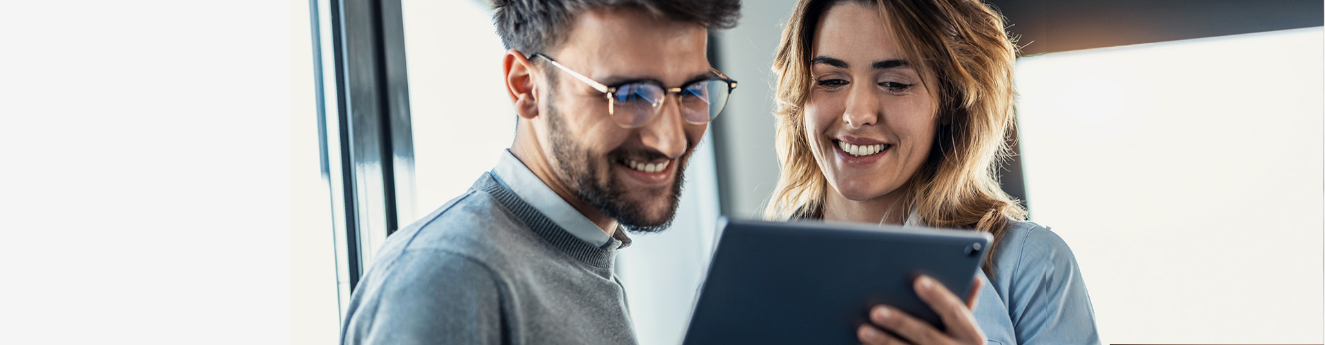 hombre y mujer en ambiente laboral mirando una tablet